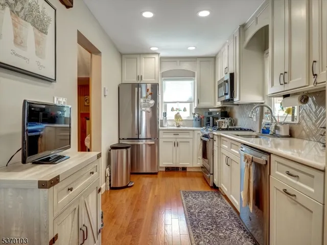a kitchen with stainless steel appliances a refrigerator sink and microwave