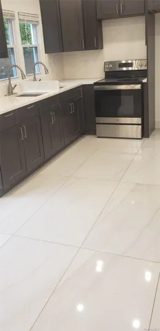 a view of kitchen with kitchen island stainless steel appliances a sink cabinets and a counter top