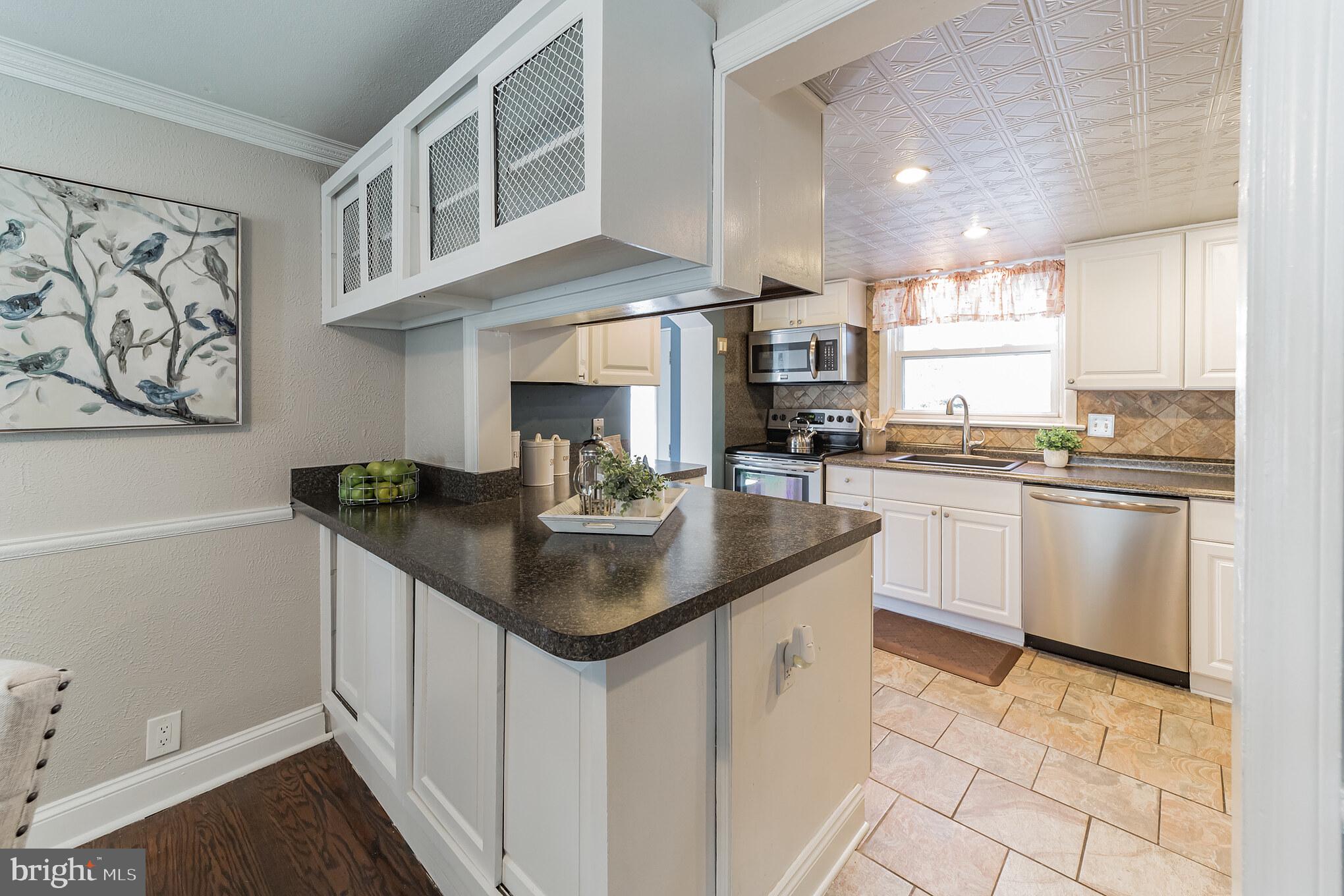 1217 Providence Road Springfield, PA 19064 - Photo 14 of 41 a kitchen with stainless steel appliances granite countertop a sink a stove and cabinets