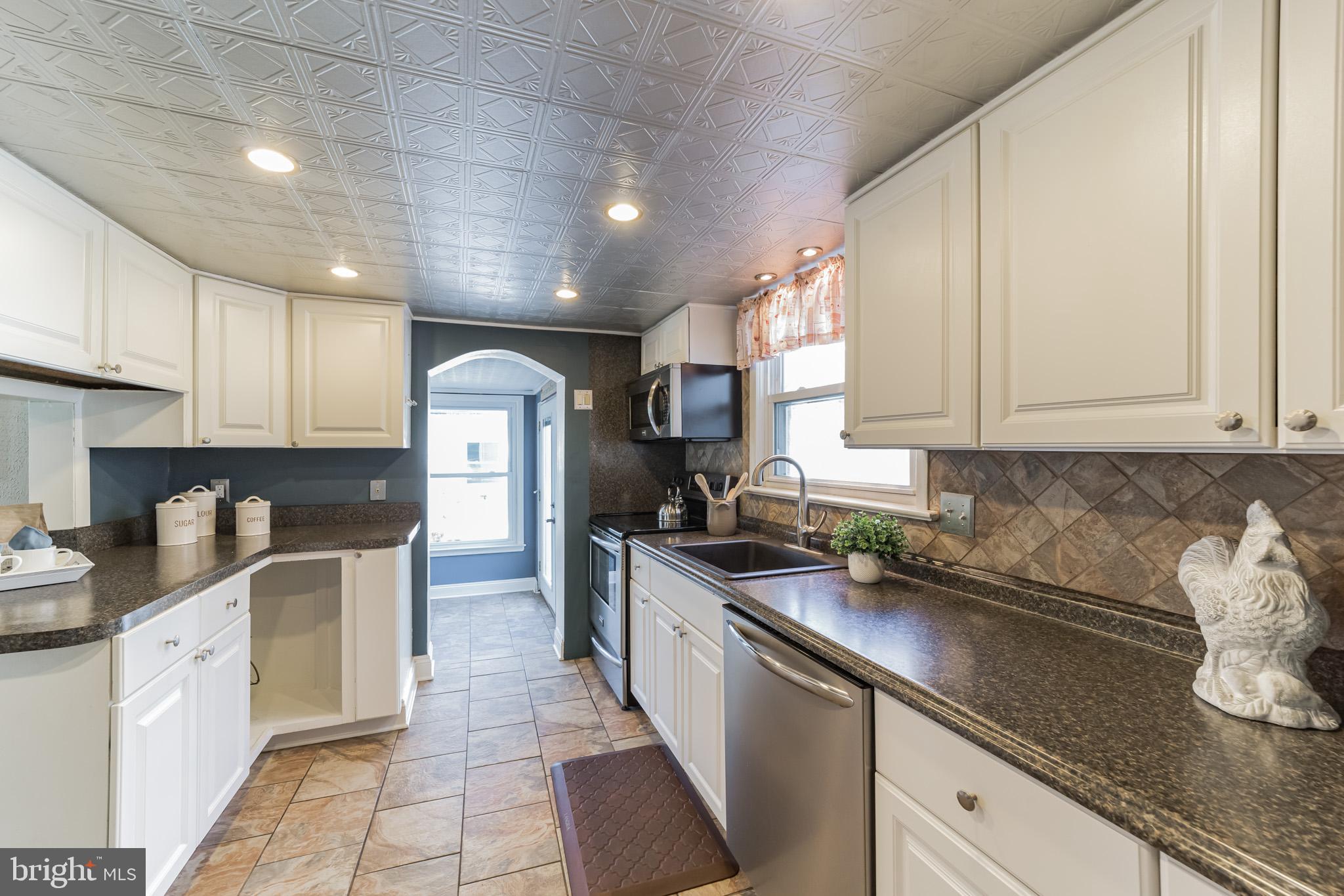 1217 Providence Road Springfield, PA 19064 - Photo 16 of 41 a kitchen with stainless steel appliances granite countertop a sink stove and cabinets