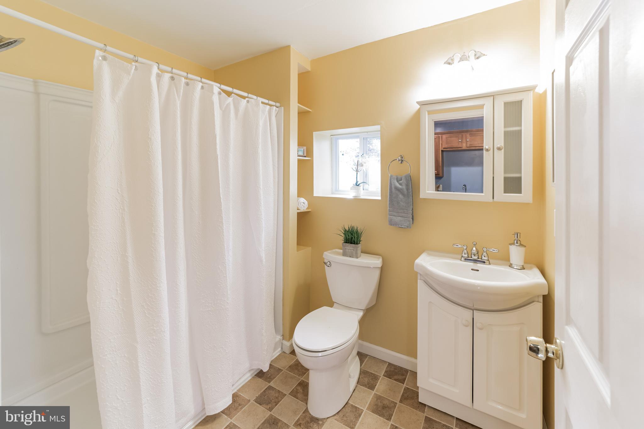 1217 Providence Road Springfield, PA 19064 - Photo 28 of 41 a bathroom with a sink a toilet and shower curtain