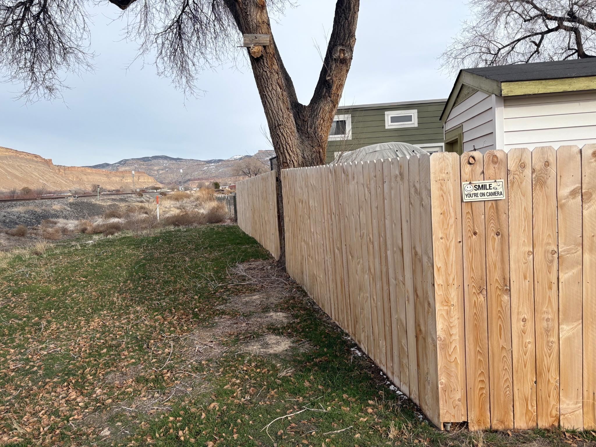 3670 G Road Palisade, CO 81526 - Photo 4 of 11 a view of a backyard with wooden fence and a large tree