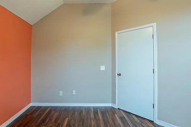 a view of an empty room with closet and a window