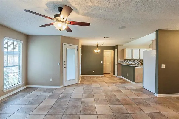 a view of an empty room with a kitchen