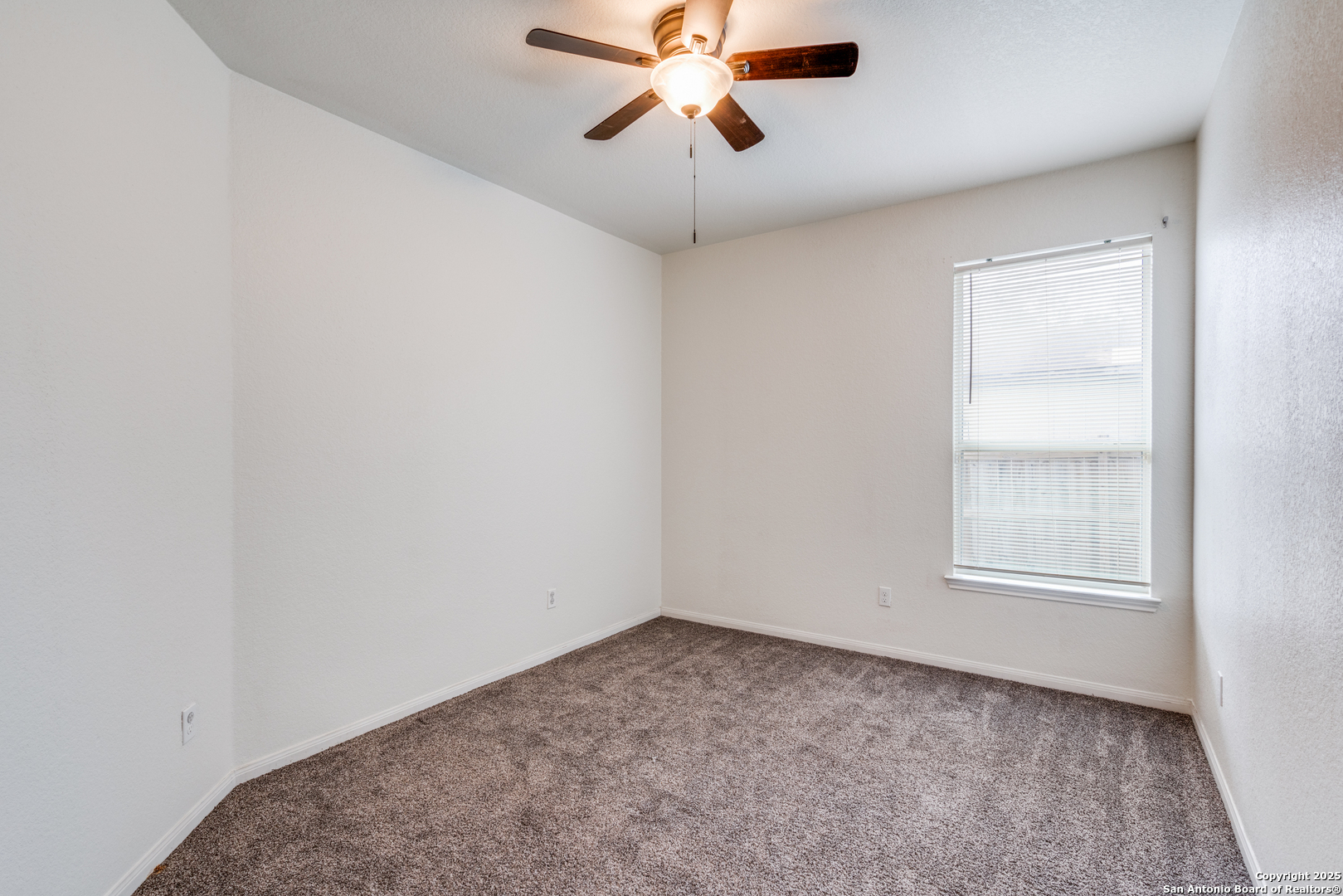 313 South 6th Street Kenedy, TX 78119 - Photo 25 of 37 an empty room with a window and a fan