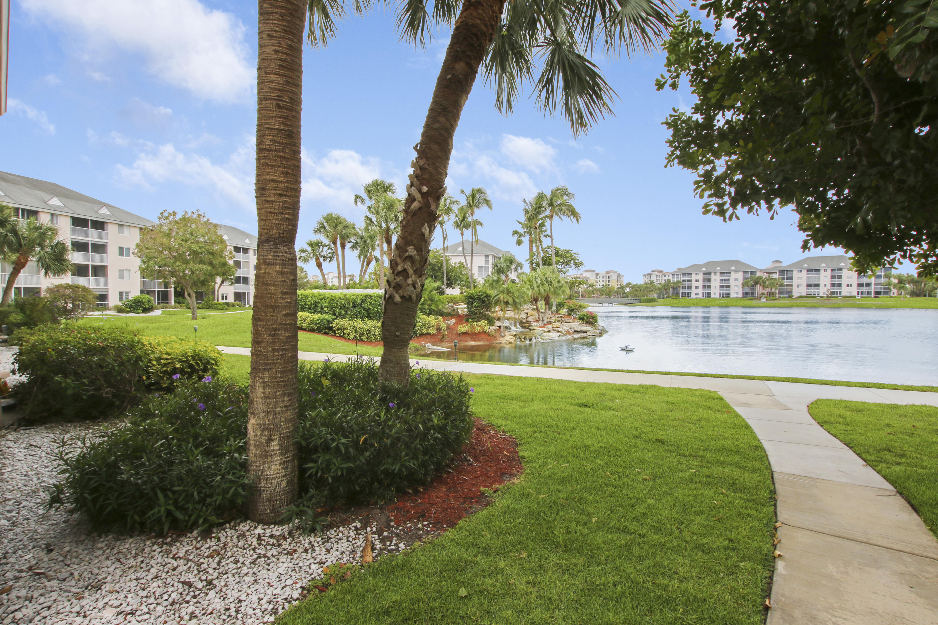 353 Highway 1, Unit C105 Jupiter, FL 33477 - Photo 2 of 33 a view of a lake with a big yard and palm trees