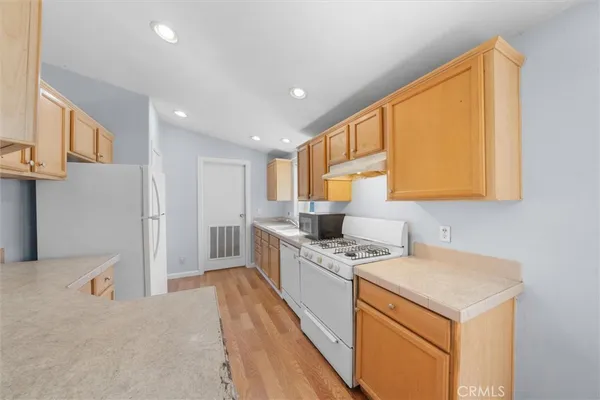 a kitchen with a stove a sink a refrigerator and cabinets