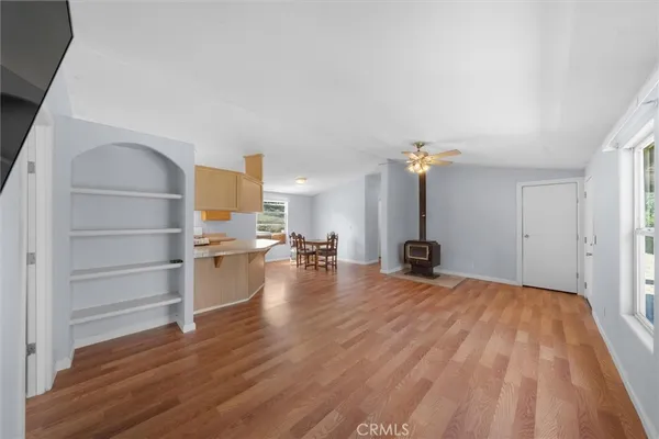 a view of a living room and kitchen with furniture and wooden floor
