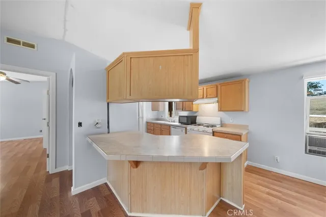 a kitchen with a sink cabinets and wooden floor