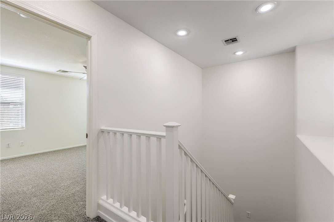 10939 Paradise Road Henderson, NV 89052 - Photo 20 of 36 Ascend to comfort with bright recessed lighting illuminating the carpeted stairway and upper-level entryway.