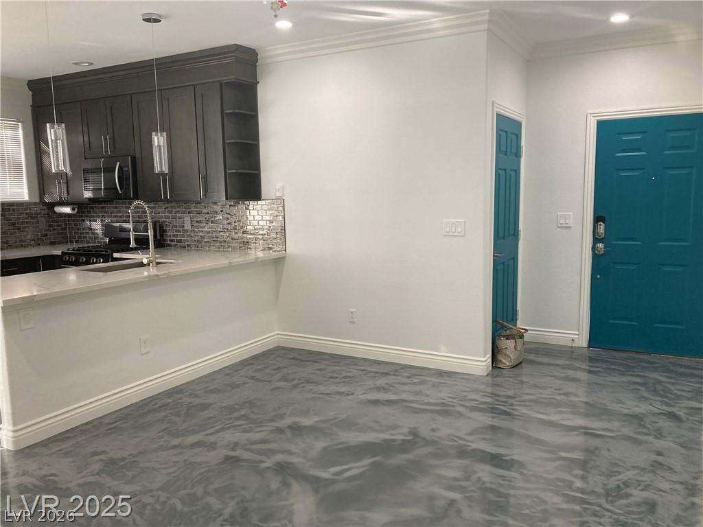 9050 West Warm Springs Road, Unit 1027 Las Vegas, NV 89148 - Photo 7 of 44 A well-appointed kitchen and entryway featuring a sleek breakfast bar and distinctive flooring.