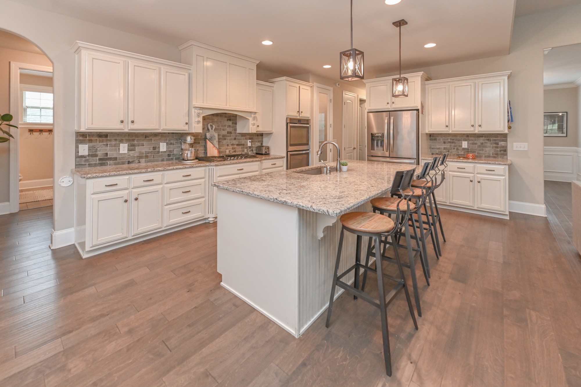 1431 Center Point Road Hendersonville, TN 37075 - Photo 6 of 20 a kitchen with stainless steel appliances kitchen island granite countertop a stove a sink a refrigerator and white cabinets with wooden floor