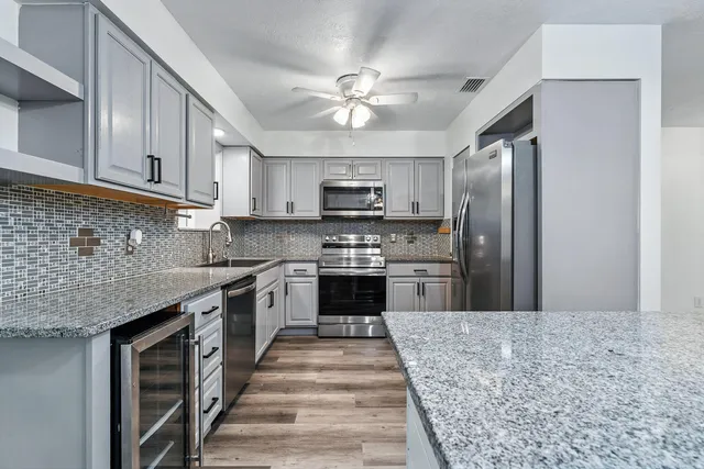 a kitchen with stainless steel appliances granite countertop a stove top oven a sink and dishwasher