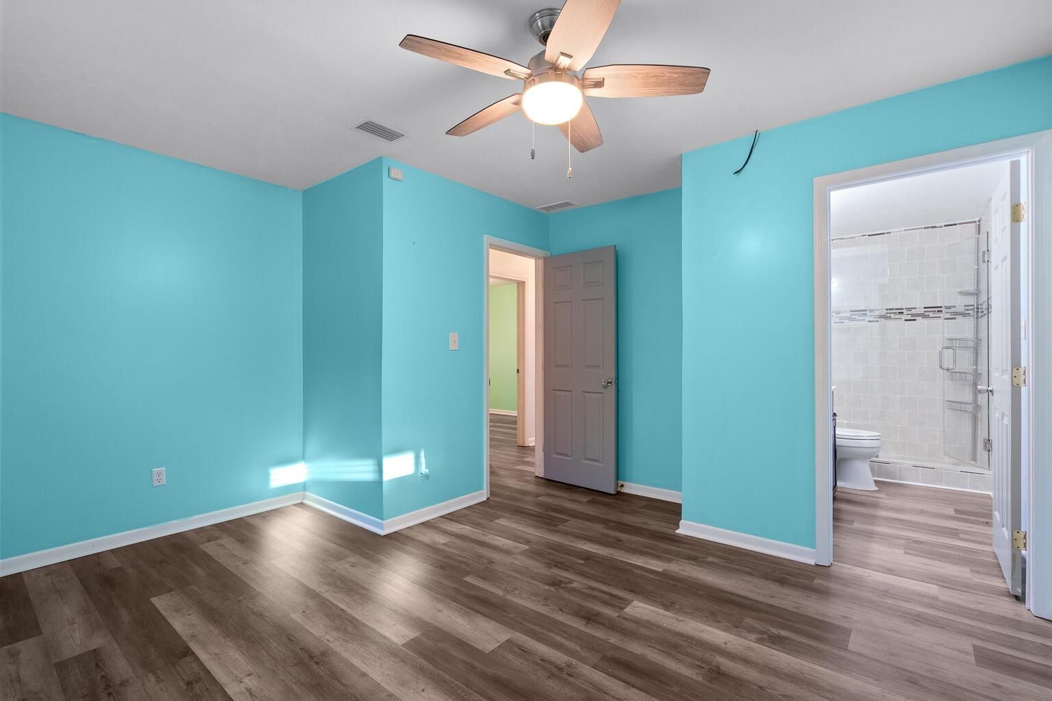 3961 Painter Branch Road Crestview, FL 32539 - Photo 14 of 49 an empty room with wooden floor and a ceiling fan
