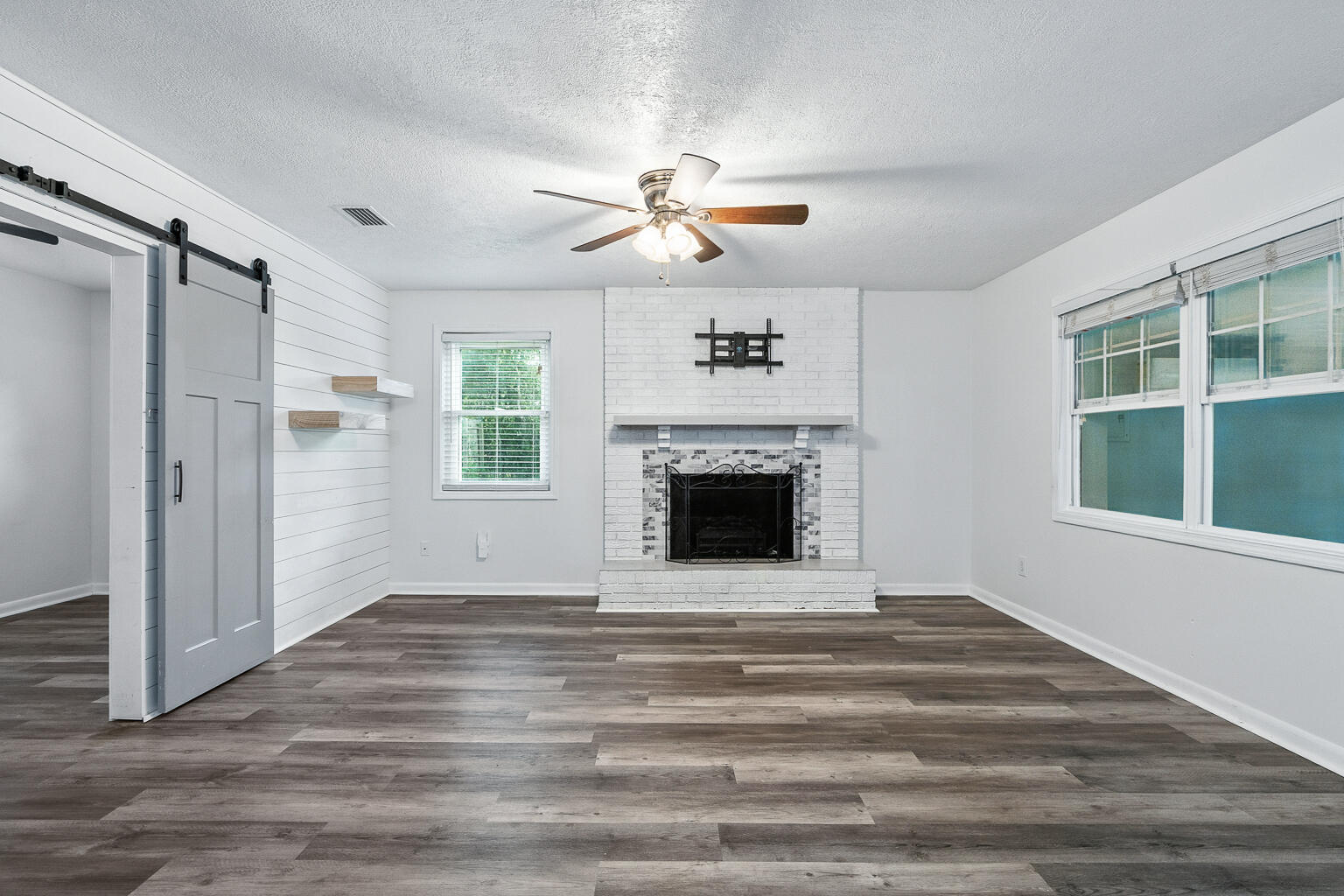 3961 Painter Branch Road Crestview, FL 32539 - Photo 41 of 49 a view of a livingroom with a fireplace a ceiling fan and windows