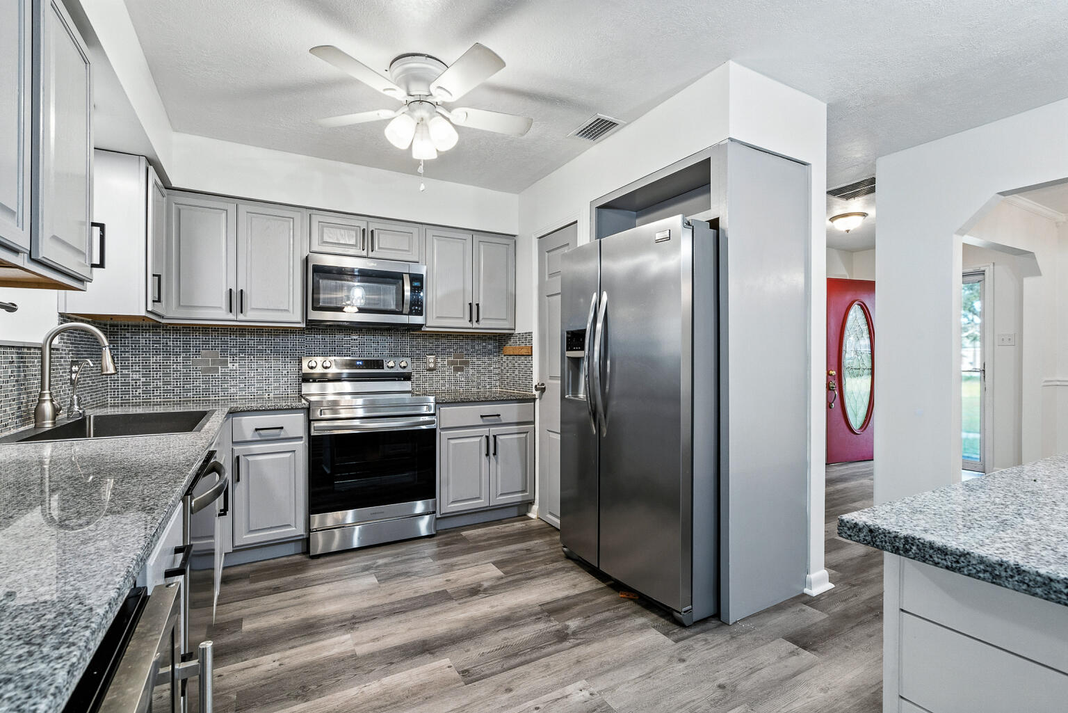 3961 Painter Branch Road Crestview, FL 32539 - Photo 8 of 49 a kitchen with stainless steel appliances granite countertop a refrigerator a stove a sink and a microwave