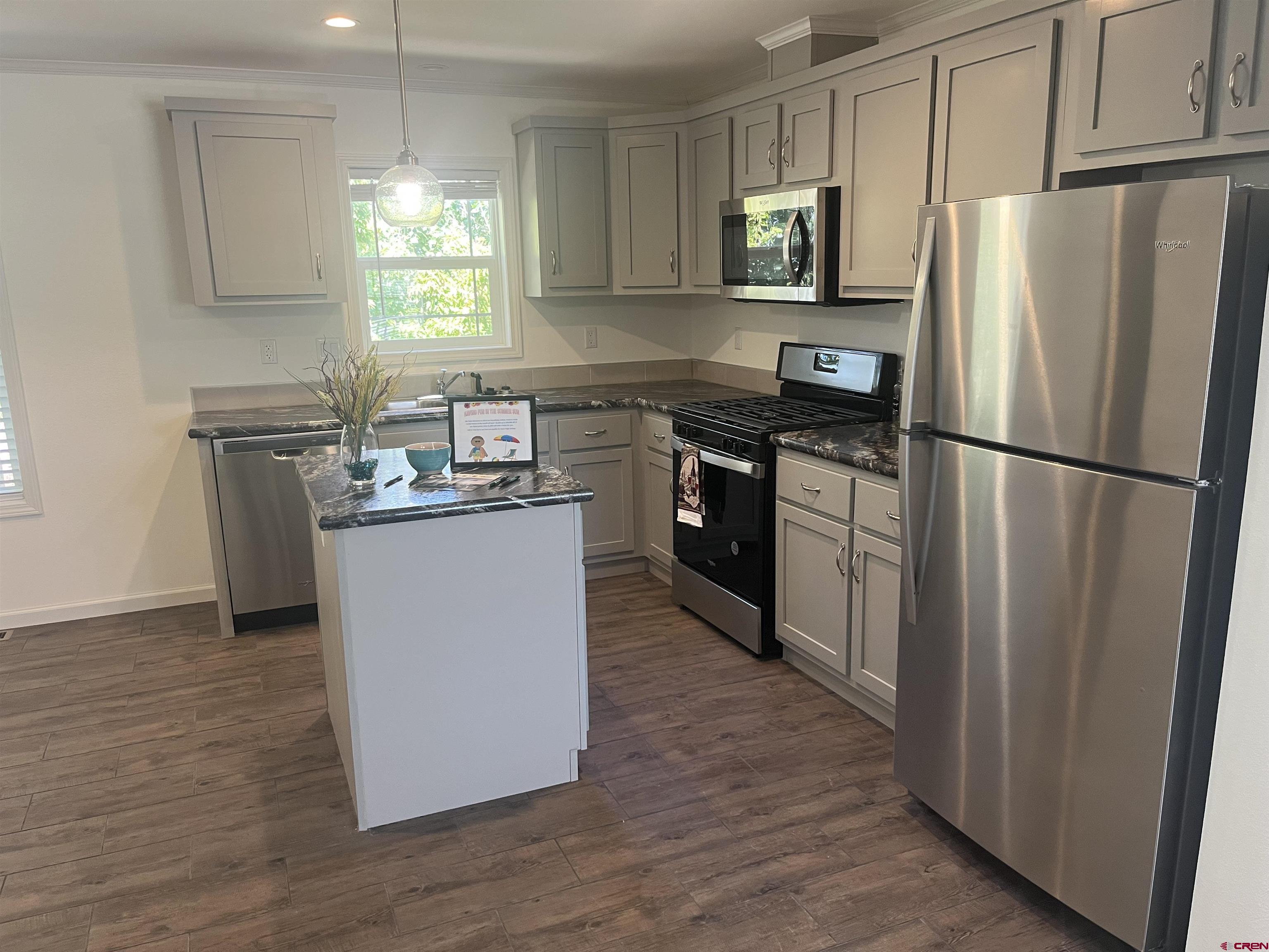 901 6530 Road, Unit 1414 Montrose, CO 81401 - Photo 3 of 16 a kitchen with a refrigerator sink and wooden floor
