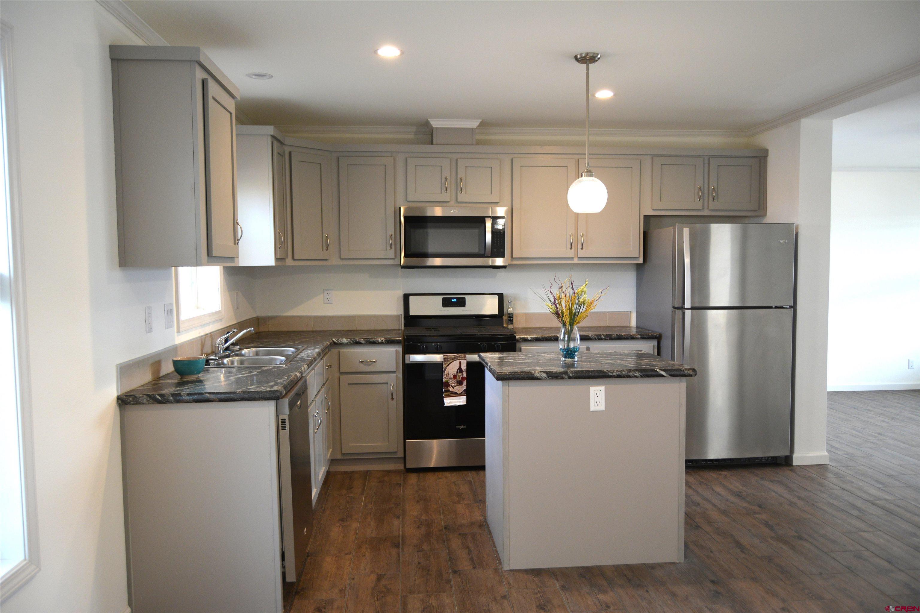 901 6530 Road, Unit 1414 Montrose, CO 81401 - Photo 4 of 16 a kitchen with a refrigerator a stove top oven and a center island