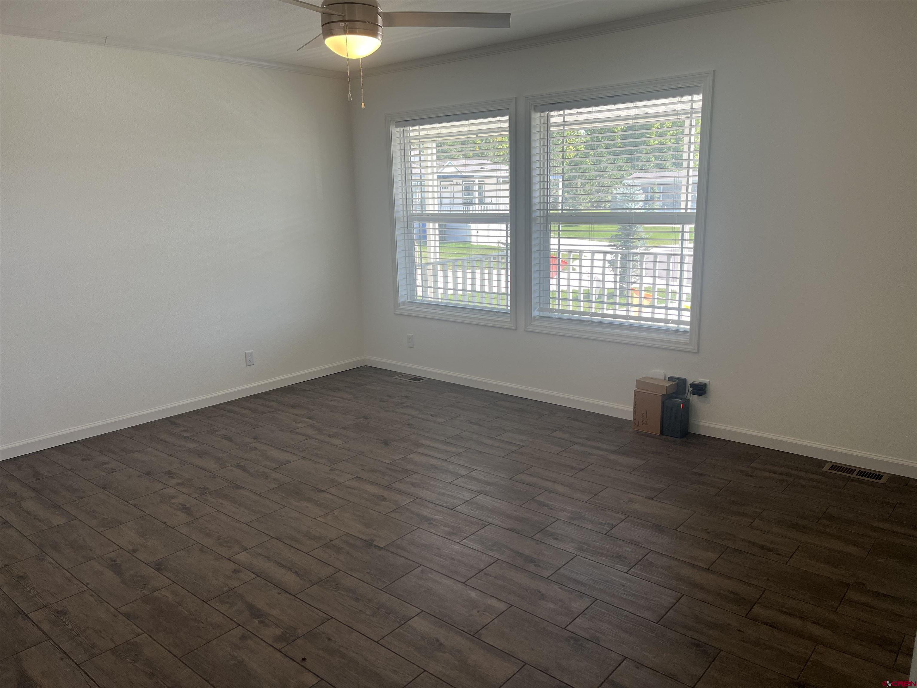 901 6530 Road, Unit 1414 Montrose, CO 81401 - Photo 5 of 16 an empty room with wooden floor and windows