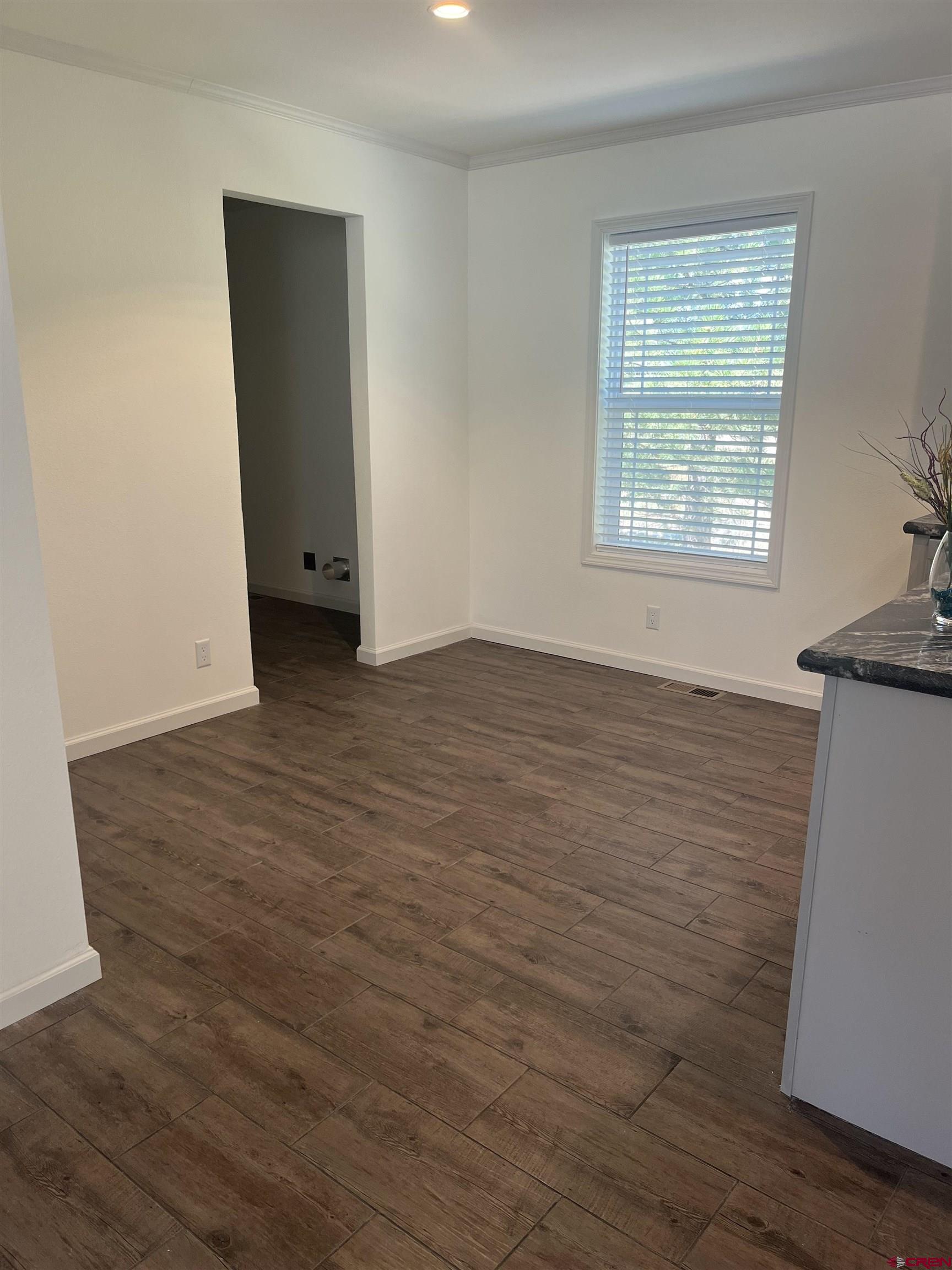 901 6530 Road, Unit 1414 Montrose, CO 81401 - Photo 9 of 16 an empty room with wooden floor and windows