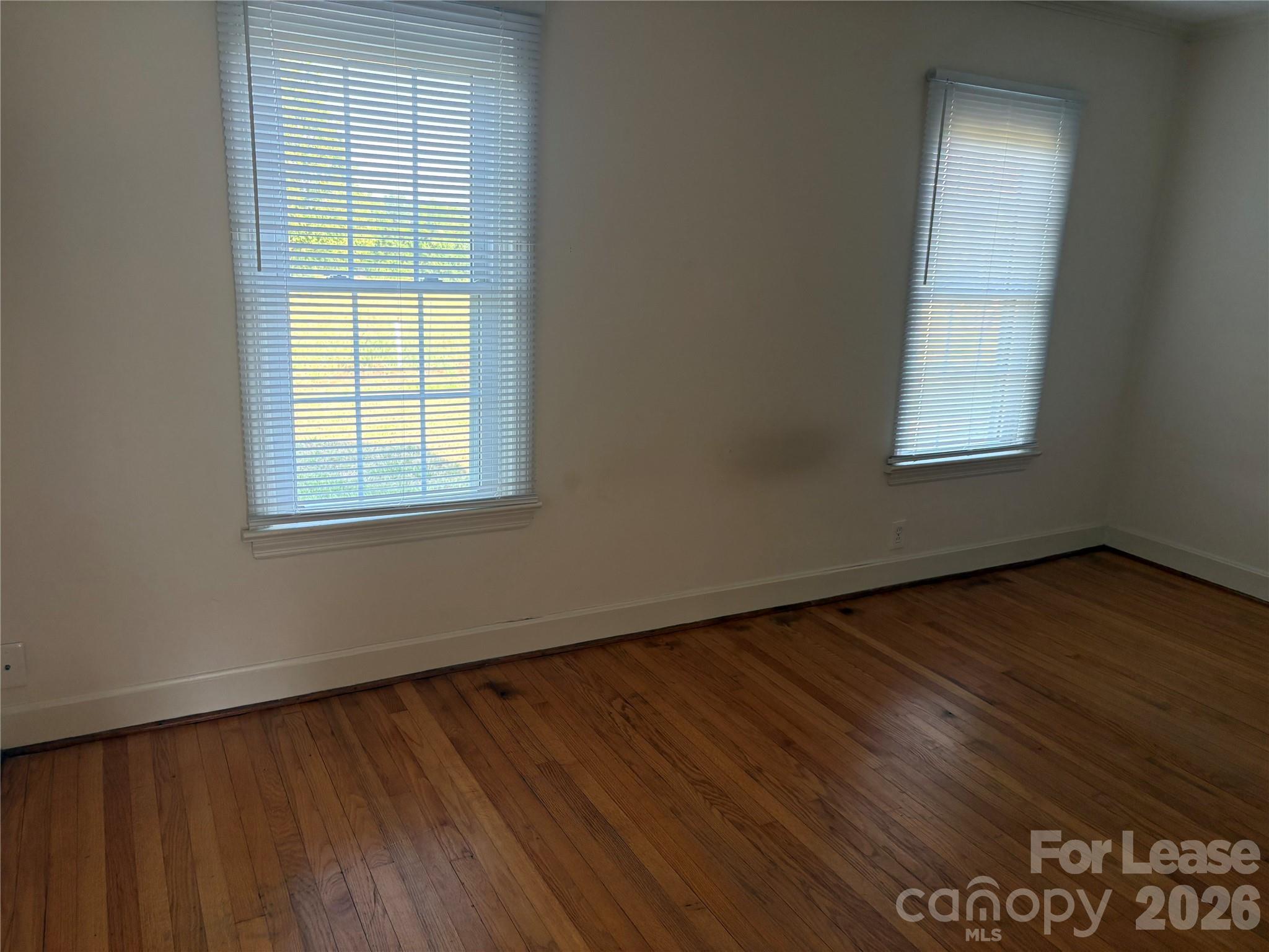 6625 Long Road Matthews, NC 28104 - Photo 12 of 21 an empty room with wooden floor and windows