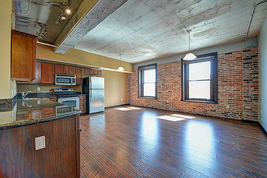 a view of a kitchen with stainless steel appliances granite countertop a stove and a wooden floors