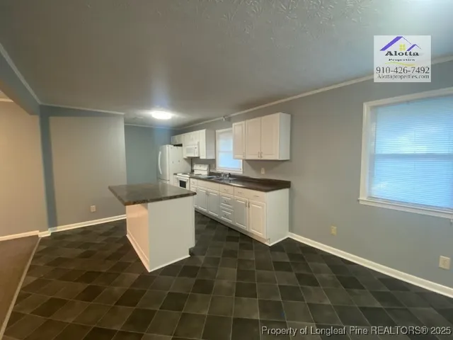 a kitchen with a sink cabinets and a window