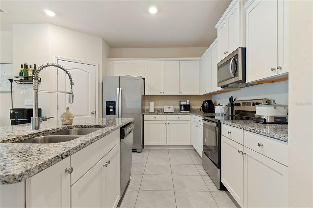 117 Redbud Road Palm Coast, FL 32137 - Photo 2 of 13 a kitchen with granite countertop a sink stainless steel appliances and white cabinets
