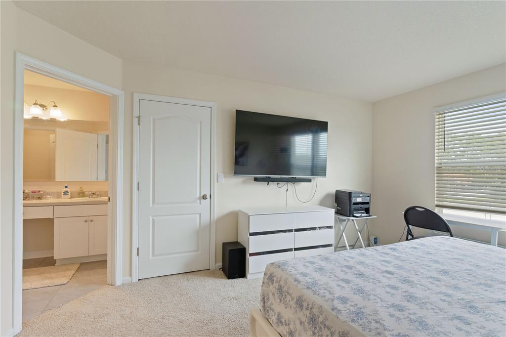 117 Redbud Road Palm Coast, FL 32137 - Photo 8 of 13 a bedroom with a bed and a flat screen tv