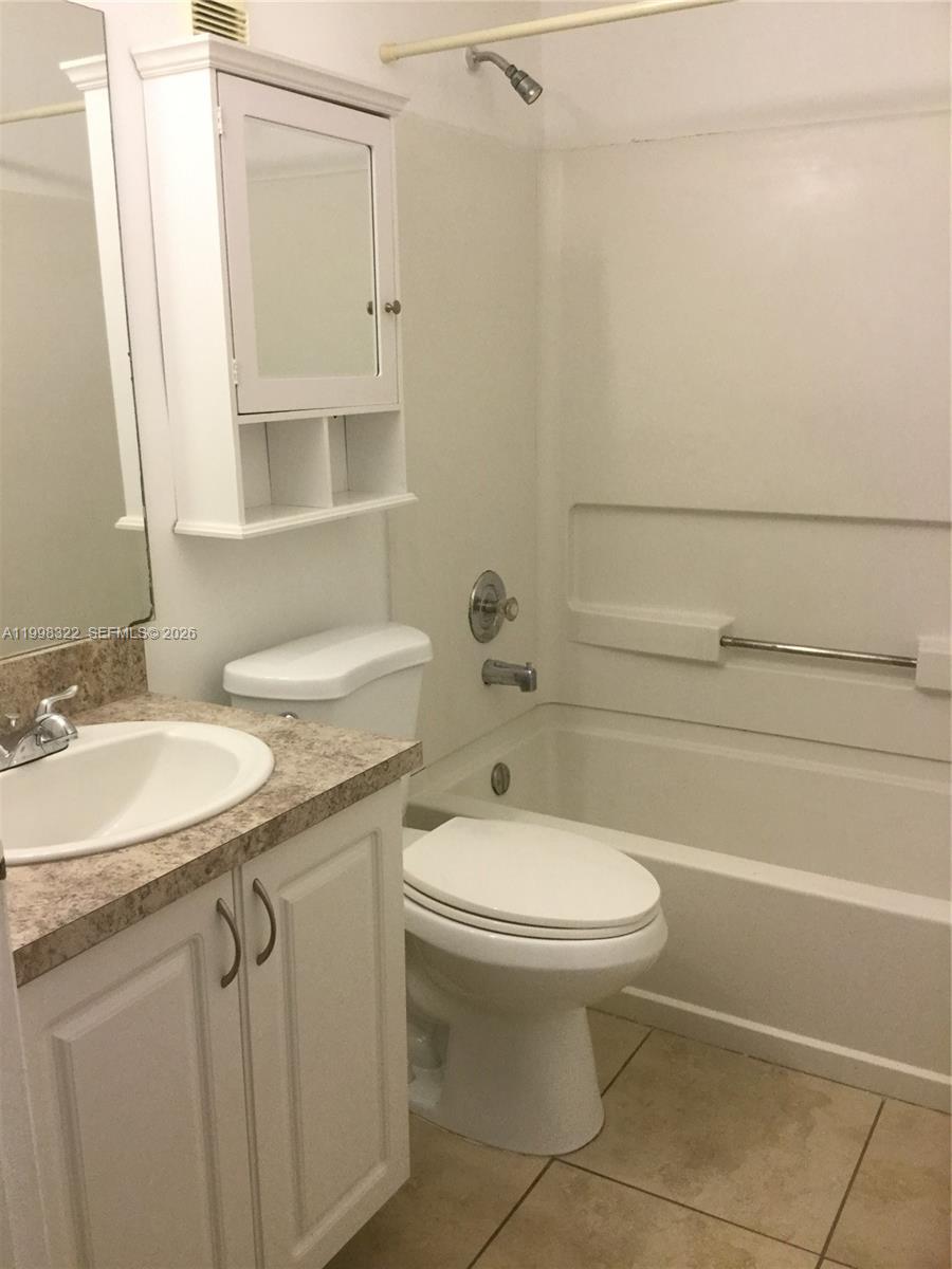 15241 Southwest 80th Street, Unit 307 Miami, FL 33193 - Photo 3 of 13 a bathroom with a granite countertop toilet sink and mirror