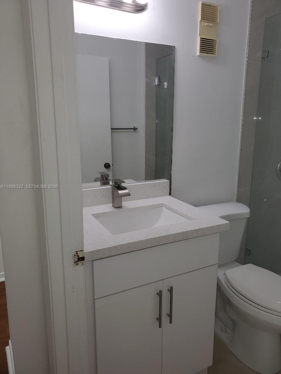 15241 Southwest 80th Street, Unit 307 Miami, FL 33193 - Photo 7 of 13 a bathroom with a sink toilet and mirror
