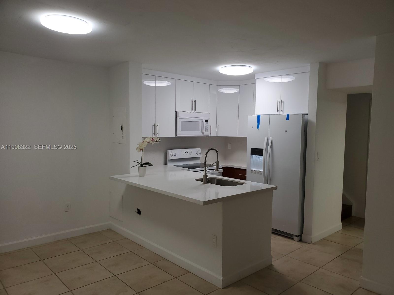15241 Southwest 80th Street, Unit 307 Miami, FL 33193 - Photo 8 of 13 a kitchen with stainless steel appliances a sink stove and refrigerator