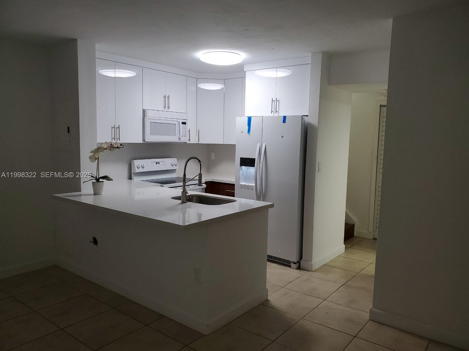 15241 Southwest 80th Street, Unit 307 Miami, FL 33193 - Photo 9 of 13 a kitchen with stainless steel appliances a sink stove and refrigerator