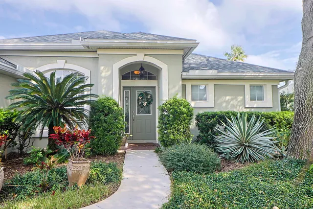 a front view of house and yard with beautiful flowers