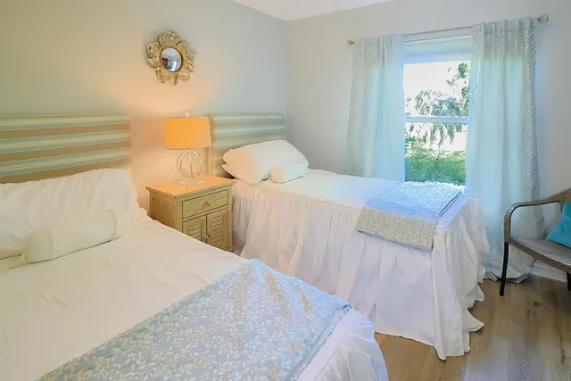 a bedroom with a bed and a flat tv screen on dresser