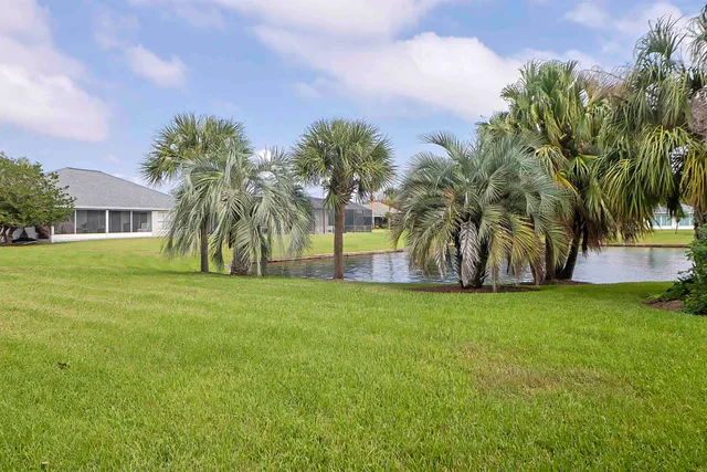 a front view of a house with a garden and tree