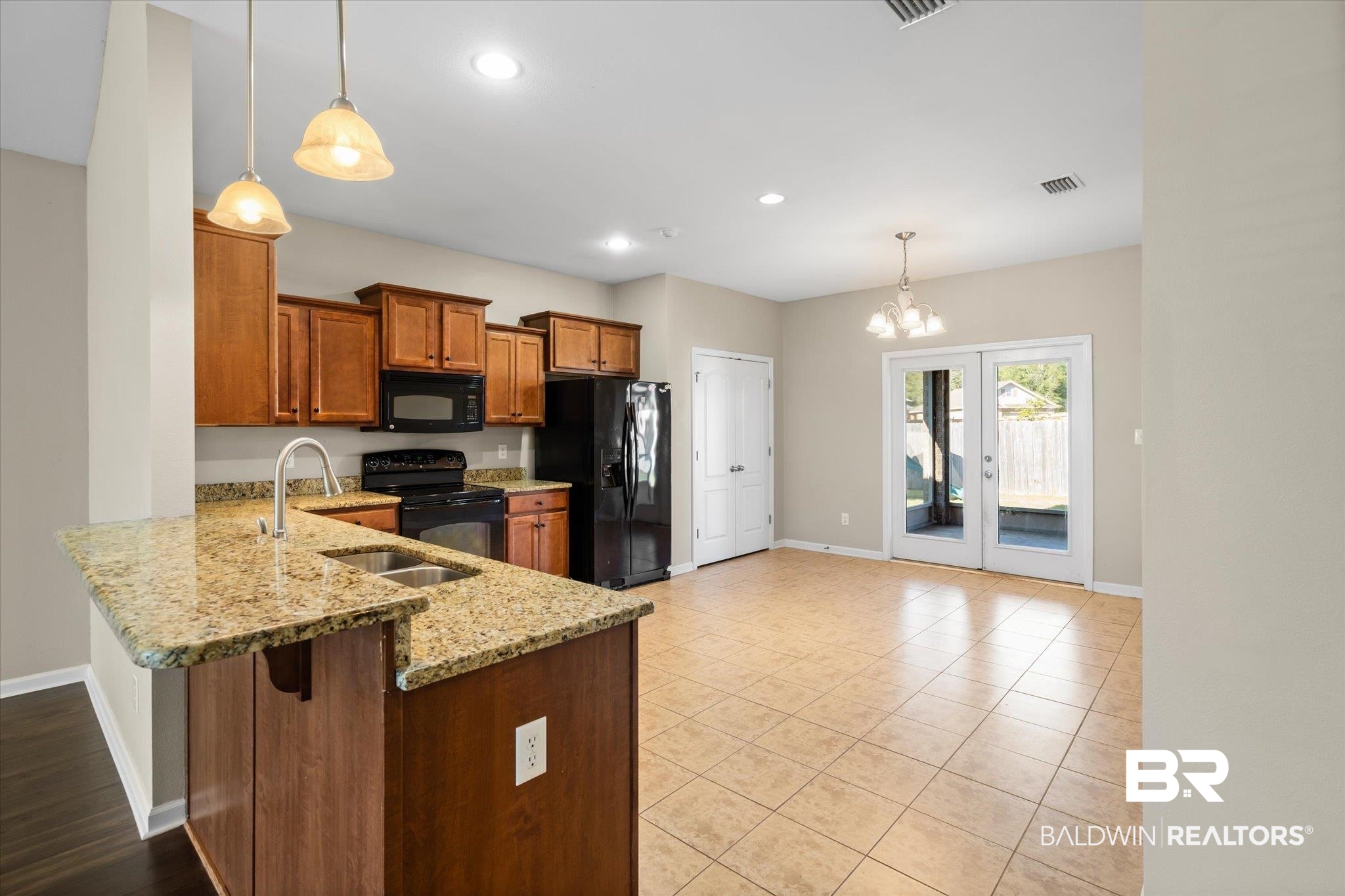 10251 Fionn Loop Daphne, AL 36526 - Photo 4 of 28 Kitchen featuring kitchen peninsula, pendant lighting, black appliances, and an inviting chandelier