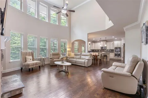 a living room with furniture and a dining table with wooden floor