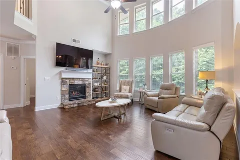 a kitchen with kitchen island granite countertop a dining table chairs refrigerator and wooden floor