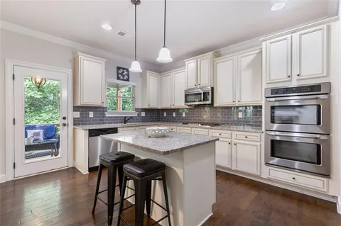 a kitchen with kitchen island granite countertop a sink a center island and cabinets