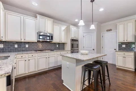 a open kitchen with stainless steel appliances granite countertop a stove and cabinets with wooden floor