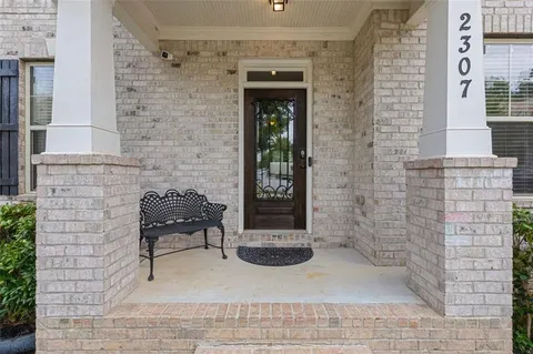 a living room with furniture a rug potted plant and a window