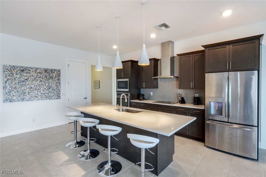 2906 Southwest 29th Terrace Cape Coral, FL 33914 - Photo 11 of 49 a kitchen with stainless steel appliances a table chairs and refrigerator