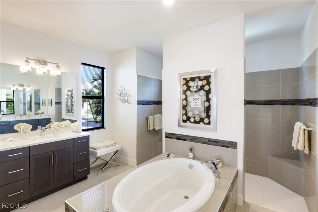 2906 Southwest 29th Terrace Cape Coral, FL 33914 - Photo 19 of 49 a bathroom with a bathtub sink mirror vanity and toilet