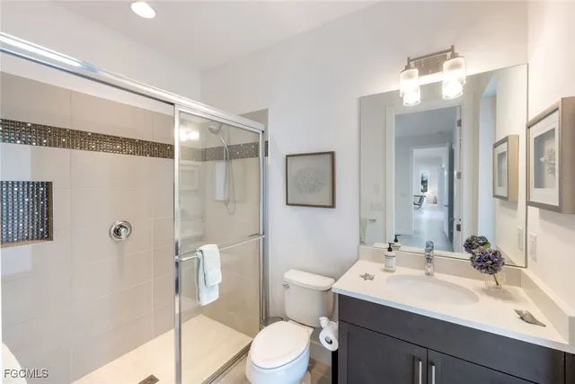 a bathroom with a sink toilet vanity and shower