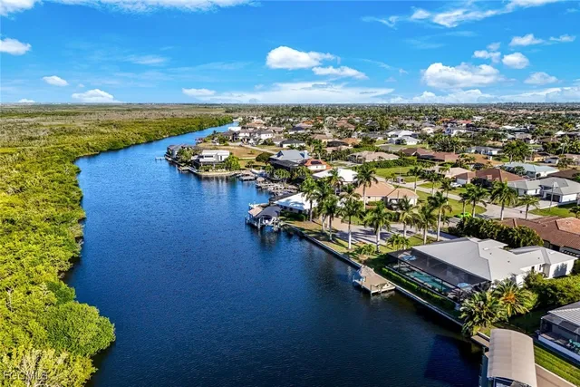 an aerial view of residential houses with outdoor space and lake view