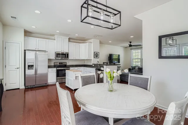 a kitchen with refrigerator and white cabinets