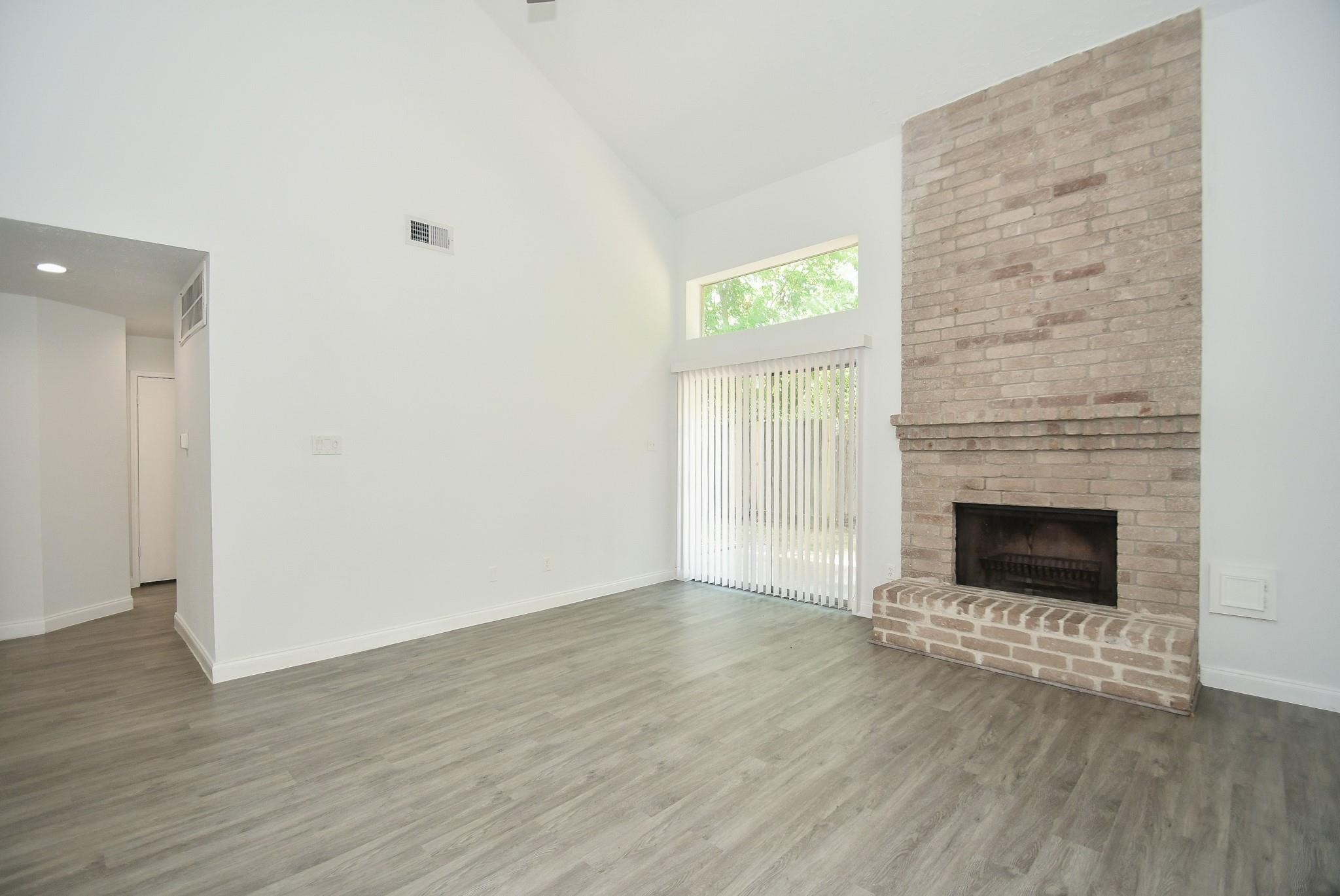 8803 Vinkins Road Houston, TX 77071 - Photo 7 of 9 an empty room with wooden floor fire place and windows