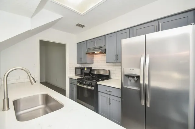a kitchen with a refrigerator sink and stove