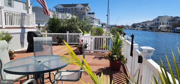a view of a balcony with wooden floor and outdoor seating
